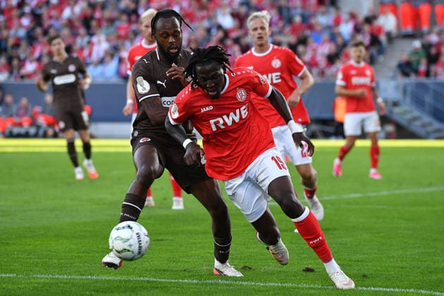 Fußball DFB-Pokal 1. Runde Rot-Weiss Essen - FC St. Pauli am 23.08.2026 im Stadion an der Hafenstraße in Essen Ricky-Jade Jones ( St. Pauli ), hinten - Franci Bouebari ( Essen ), vorne DFB regulations prohibit any use of photographs as image sequences and or quasi-video. *** Soccer: DFB Cup, First Round—Rot-Weiss Essen vs. FC St. Pauli on August 23, 2026, at the Stadion an der Hafenstraße in Essen. Ricky Jade Jones (St. Pauli), with Franci Bouebari (Essen) in the background and DFB regulations prohibit any use of photographs as image sequences and or quasi-video. xRx