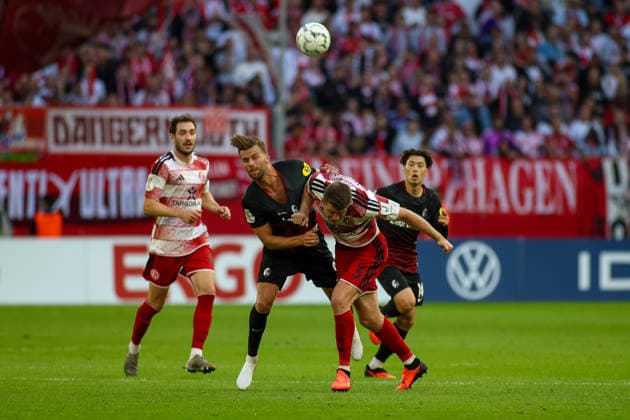 23.08.2026, GER, Fussball, Herren, DFB Pokal , Saison 2026 2027, Fortuna Düsseldorf - SC Freiburg Lucas Höler (SCF) und Dominique Heintz (F95) im Kampf um den Ball *** August 23, 2026, GER, Soccer, Men s, DFB Cup, 2026–2027 Season, Fortuna Düsseldorf vs. SC Freiburg: Lucas Höler (SCF) and Dominique Heintz (F95) battle for the ball Copyright: xSvenxHanischx