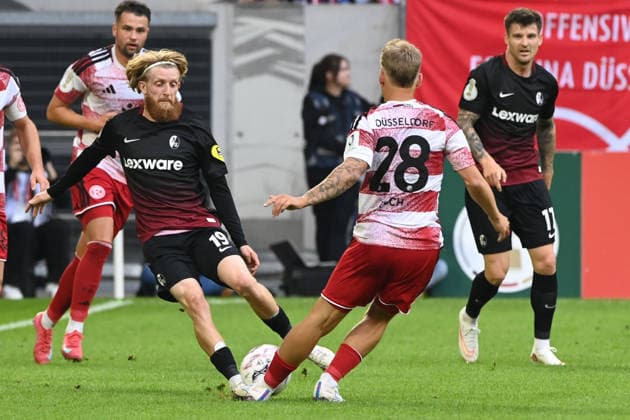 Niklas BESTE (FR) gegen Sascha RISCH (D) Aktion, Zweikampf, Fussball DFB Pokal, 1. Hauptrunde, Fortuna Duesseldorf (D) - SC Freiburg (FR) 1-5 am 23.08.2026 in der Merkur Spiel Arena Duesseldorf Deutschland. DFL DFB regulations prohibit any use of photographs as image sequences and or quasi-video Â *** Niklas BESTE (FR) vs. Sascha RISCH (D) – Action, Tackle, Soccer, DFB Cup, 1st Round, Fortuna Düsseldorf vs. SC Freiburg, Friday, August 23, 2026, at the Merkur Spiel Arena in Düsseldorf, Germany. DFL and DFB regulations prohibit any use of photographs as image sequences and or quasi-video.