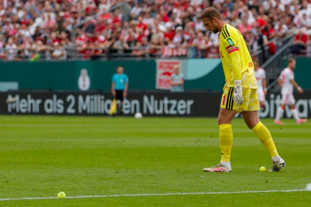 Im Bild: Fans werfen aus Protest Tennisbaelle auf das Spielfeld, Torwart Marvin Schwaebe (1. FC Koeln, 1) mitten im Geschehen. 24.08.2026, FC Wuerzburger Kickers - 1. FC Koeln, DFB-Pokal, 1. Runde, Deutschland, Wuerzburg, AKON-Arena, DFL REGULATIONS PROHIBIT ANY USE OF PHOTOGRAPHS AS IMAGE SEQUENCES AND OR QUASI-VIDEO. *** In the photo, fans throw tennis balls onto the field in protest; goalkeeper Marvin Schwaebe of 1. FC Köln, 1, is right in the thick of the action, August 24, 2026, FC Würzburger Kickers vs. 1. FC Köln, DFB Cup, First Round, Germany, Würzburg, AKON Arena, DFL regulations prohibit any use of photographs as image sequences and or quasi-video Copyright: HMBxMedia xJulienxBecker
