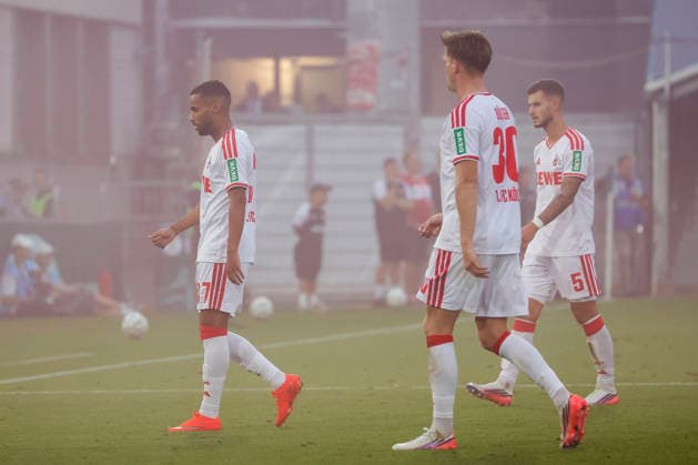 Im Bild: v.li. Linton Maina (1. FC Koeln, 37), Marius Buelter (1. FC Koeln, 30) und Tom Krauß (1. FC Koeln, 5) laufen zur Bank weil das Spielfeld durch Pyrotechnik zugenebelt ist. 24.08.2026, FC Wuerzburger Kickers - 1. FC Koeln, DFB-Pokal, 1. Runde, Deutschland, Wuerzburg, AKON-Arena, DFL REGULATIONS PROHIBIT ANY USE OF PHOTOGRAPHS AS IMAGE SEQUENCES AND OR QUASI-VIDEO. *** In the photo, from left: Linton Maina (1. FC Köln, 37), Marius Buelter (1. FC Köln, 30), and Tom Krauß (1. FC Köln, 5) are running toward the bench because the field is shrouded in smoke from pyrotechnics. August 24, 2026, FC Würzburger Kickers vs. 1. FC Köln, DFB Cup, First Round, Germany, Würzburg, AKON Arena. DFL regulations prohibit any use of photographs as image sequences and or quasi-video. Copyright: HMBxMedia xJulienxBecker