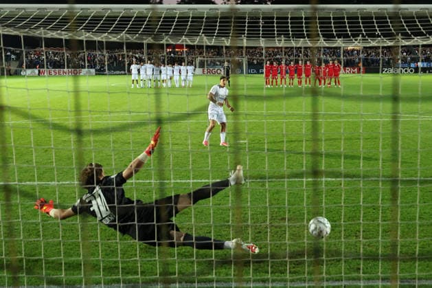 BERLIN, GERMANY - AUGUST 24: Noah Can Kardam (VSG Altglienicke, 27) scores by penalty against Torwart Goal Keeper Jakub Zielinski (Wolfsburg, 30) in the goal, during the DFB Cup DFB Pokal match (Round 1) between DFB-Pokal: VSG Altglienicke - VfL Wolfsburg at Stadion auf dem Wurfplatz (Amateurstadion im Olympiapark) on August 24, 2026 in Berlin, Germany. DFL REGULATIONS PROHIBIT ANY USE OF PHOTOGRAPHS AS IMAGE SEQUENCES AND OR QUASI-VIDEO. Berlin Germany Copyright: xO.Frankex