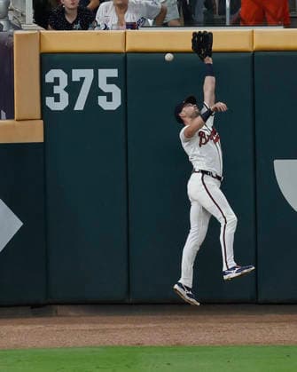 Left fielder Lane Thomas 20 of the Atlanta Braves jumps but cannot catch a fly ball hit by designated hitter Shohei Ohtani 17 of the Los Angeles Dodgers (not pictured) in the ninth inning at Truist Park on Tuesday, August 25, 2026 in Atlanta, Georgia.  ATL20260825109 MikexZarrilli