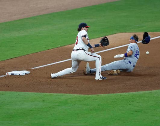 Left fielder Alex Call 12 of the Los Angeles Dodgers slides into third base before a throw by Ronald Acuna, Jr. 13 of the Atlanta Braves (not pictured) past third baseman Austin Riley 27 in the fourth inning against the Los Angeles Dodgers the Atlanta Braves at Truist Park on Tuesday, August 25, 2026 in Atlanta, Georgia.  ATL20260825118 MikexZarrilli