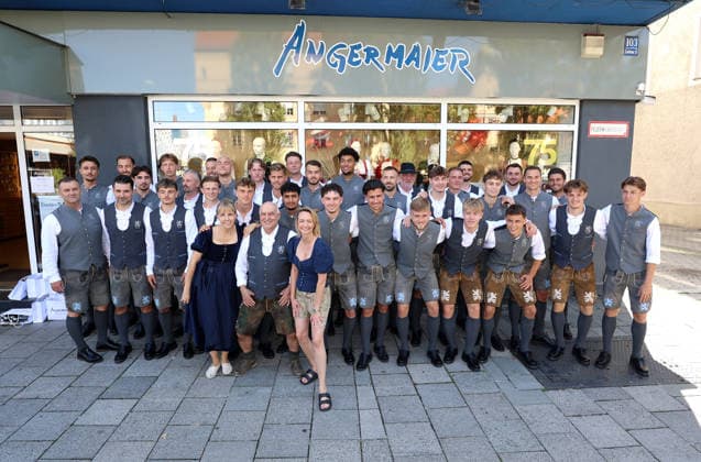 Soccer, Men s, Oktoberfest Uniforms, 2026–2027 Season, TSV 1860 Munich, Trachten Angermaier: The players, the TSV 1860 Munich team posing together in front of the Trachten Angermaier store, team photo, in traditional attire, wearing lederhosen with Axel Munz