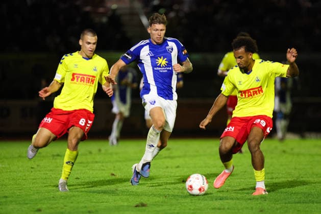 August 26, 2026, Soccer, Men s, Regionalliga Nord, Matchday 5, SV Atlas Delmenhorst vs. BSV Kickers Emden, Luc Ihorst (blue, No. 14) of BSV Kickers Emden in a duel with Yegor Melenivskyi (No. 6) of SV Atlas Delmenhorst and goalkeeper Kilian Sanden (No. 26) of SV Atlas Delmenhorst