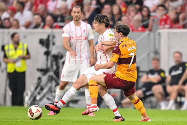 Yuito Suzuki of SC Freiburg and Joe Hodge of Motherwell FC battle for the ball during the second leg of the 2026-27 UEFA Conference League Playoff Round between Sport Club Freiburg and Motherwell at Stadion am Wolfswinkel on August 27, 2026, in Freiburg, Germany. Photo by Harry Langer, DeFodi Images