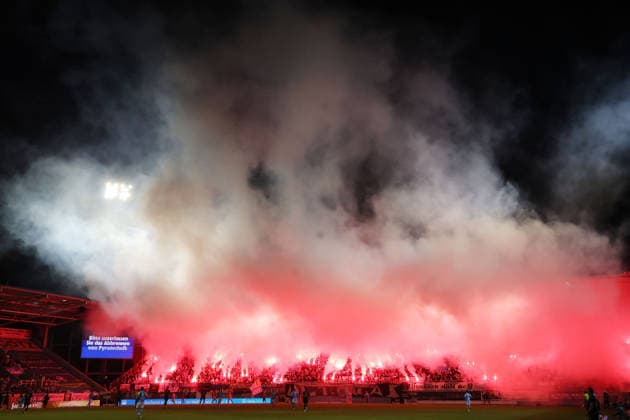 White and red smoke from numerous Bengal flares drifts over the Jena penalty area and the home team’s south stand during the second half at the eins stadium on Gellertstrasse in Chemnitz, Chemnitzer FC vs. Carl Zeiss Jena, Matchday 7, 2026–27 Northeast Regional League, Saxony, Germany, August 28, 2026, high-risk match,