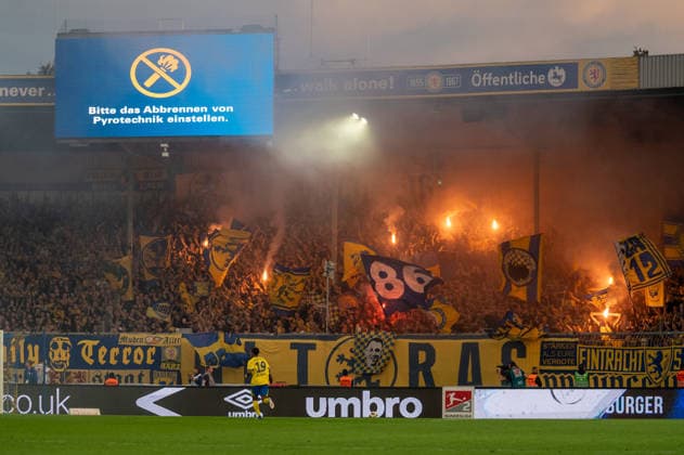 Deutschland: Fussball 2. Bundesliga, 3. Spieltag 2026 2027, Eintracht Braunschweig - Hertha BSC am 28.08.2026 in Braunschweig (Eintracht-Stadion): Fans von Eintracht Braunschweig zünden Pyrotechnik im Fanblock. Auf der Stadionanzeige werden die Zuschauer mit dem Hinweis Bitte das Abbrennen von Pyrotechnik einstellen zum Beenden der Pyrotechnik aufgefordert. Eintracht Braunschweig, BTSV, Braunschweig, Eintracht, Fußball, Fussball, Fans, Fußballfans, Fussballfans, Anhänger, Ultras, Fanszene, Fankultur, Fanblock, Fankurve, Kurve, Tribüne, Pyrotechnik, Pyro, Bengalo, Bengalos, Bengalisches Feuer, Leuchtfackel, Fackeln, Rauch, Rauchentwicklung, Rauchwolke, Stadion, Fußballstadion, Fussballstadion, Stadionanzeige, Videowand, Anzeigetafel, Bitte das Abbrennen von Pyrotechnik einstellen, Pyrotechnik Verbot, Verbot, Sicherheitswarnung, Sicherheit, Stadionordnung, Spielunterbrechung, DFB, Bundesliga, 2. Bundesliga, Profifußball, Profifussball, Fanschals, Fahnen, Fanflaggen, Stimmung, Stadionatmosphäre, Niedersachsen, Deutschland *** German Soccer 2. Bundesliga, Matchday 3, 2026–2027, Eintracht Braunschweig vs. Hertha BSC on August 28, 2026, at Eintracht Stadium in Braunschweig. Eintracht Braunschweig fans set off pyrotechnics in the fan section. The stadium display shows a message urging spectators to Please stop setting off pyrotechnics to get them to stop.Eintracht Braunschweig, BTSV, Braunschweig, Eintracht, soccer, fans, soccer fans, supporters, Ultras, fan scene, fan culture, fan section, fan curve, curve, stands, pyrotechnics, pyro, Bengalo, Bengalos, Bengal fire, flares, smoke, smoke development, smoke cloud, stadium, soccer stadium, soccer stadium, stadium display, video wall, scoreboard, Please stop setting off pyrotechnics, pyrotechnics ban, ban, safety warning, safety, stadium rules, game interruption, DFB, Bundesliga, 2. Bundesliga, professional soccer, fan scarves, flags, fan banners, atmosphere, stadium atmosphere, Lower Saxony, Germany Copyright: xSvenxHeidmannx