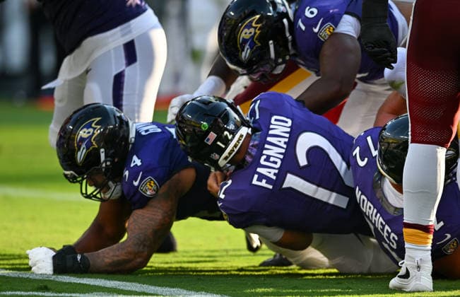 Baltimore Ravens quarterback Joe Fagnano (12) runs from the 1 yard line to score a touchdown against the Washington Commanders with blocking from center Jovaughn Gwyn (54) during the first quarter of a preseason game at M&T Bank Stadium in Baltimore, Maryland, on Friday, August 28, 2026.  BAL20260828102 DAVIDxTULIS