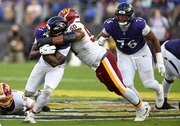 Washington Commanders defensive tackle Ricky Barber (50) wraps up Baltimore Ravens running back Adam Randall (2for a tackle on third down at midfield during the second quarter of a preseason game at M&T Bank Stadium in Baltimore, Maryland, on Friday, August 28, 2026.  BAL20260828106 DAVIDxTULIS