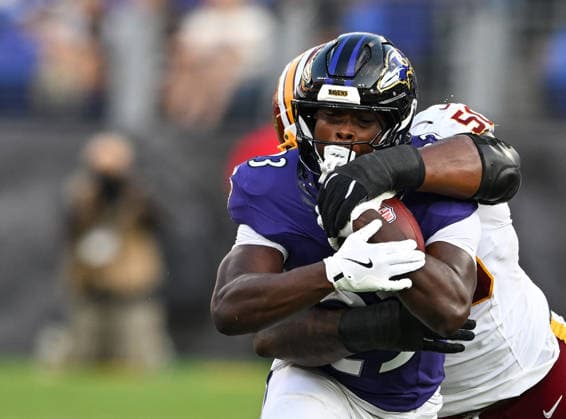 Washington Commanders defensive tackle Ricky Barber (50) stops Baltimore Ravens running back Adam Randall (23) on third down at midfield during the second quarter of a preseason game at M&T Bank Stadium in Baltimore, Maryland, on Friday, August 28, 2026.  BAL20260828107 DAVIDxTULIS
