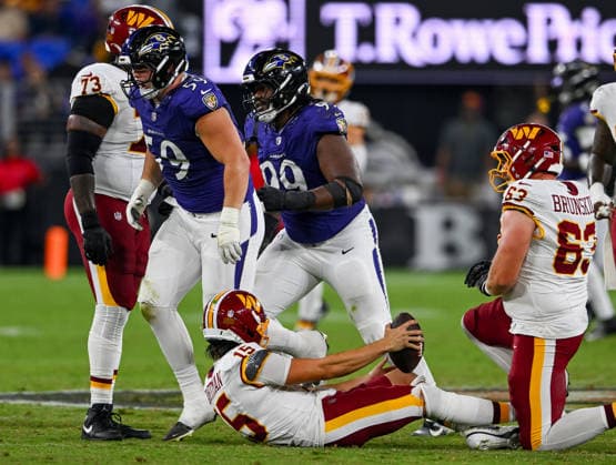 Washington Commanders quarterback Sam Hartman (15) is sacked by Baltimore Ravens defensive tackle Aaron Graves (59) for a 6 yard loss during the fourth quarter of a preseason game at M&T Bank Stadium in Baltimore, Maryland, on Friday, August 28, 2026. The Ravens won 41-3.  BAL20260828130 DAVIDxTULIS