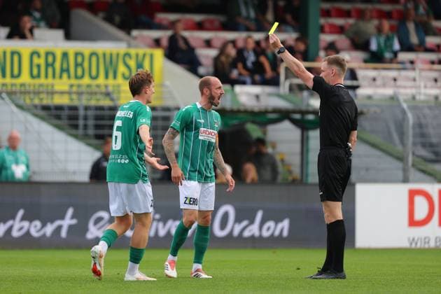 August 29, 2026, GER, Regionalliga Nord, Soccer, Matchday 6, 2026–2027 Season, VfB Lübeck vs. SV Drochtersen Assel Yellow card: Referee Mika Jungclaus shows Marvin Thiel (VfB Lübeck 13) a yellow card. On the left: Bjarne Pfundheller (VfB Lübeck 06). Lübeck, Dietmar Scholze Stadium at Lohmuehle, SH, Germany Copyright: xnordphotoxGmbHx xTauchnitzx