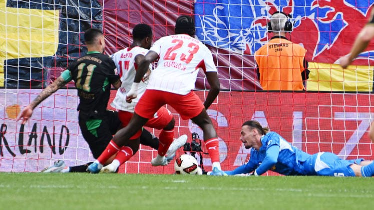 Bundesliga, 2026–2027 Season, Matchday 1, RB Leipzig vs. VfL 1900 Borussia Mönchengladbach, August 29, 2026. Maarten Vandevoordt, goalkeeper for RB Leipzig, No. 26, in the middle, deflects a shot on goal to the post during the Bundesliga match between Leipzig and Mönchengladbach on August 29, 2026, and saves the follow-up shot from Tim Kleindienst, center forward for Borussia Mönchengladbach, No. 11, Ridle Baku, right back for RB Leipzig, No. 17, Castello Lukeba, center back for RB Leipzig, No. 23, also involved. Leipzig, Saxony, Germany, Red Bull Arena