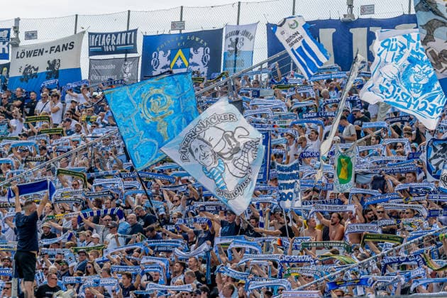 The Löwen fans in the Westkurve await the kickoff of the match between GER, TSV 1860 Munich, and TSV Landsberg 1882—soccer, Bavarian Regional League, Matchday 6, 2026–2027 season—with a scarf parade, August 30, 2026 DFL DFB REGULATIONS PROHIBIT ANY USE OF PHOTOGRAPHS as IMAGE SEQUENCES and or QUASI-VIDEO Photo: HMB Media, Heike Feiner Copyright: HMBxMedia HeikexFeiner