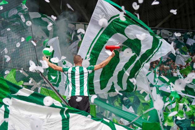 Deutschland: Fussball Bundesliga Saison 2026 - 2027, 1. Spieltag - SC Freiburg vs Werder Bremen - Europa Park Stadion (Freiburg): Fankurve von Werder Bremen im Stadion: Vorsänger mit Megafon vor dicht gedrängten Fans, umgeben von großen grün-weißen Schwenkfahnen. Grüner Rauch, Konfetti und Luftschlangen prägen die Choreographie. Zuschauer, Fans, Ultras, Supporter, Tribüne, Fanblock, Fankultur, Fanchoreo, Choreographie, Fahnenmeer, Megafon, Rauch, Pyrotechnik, Konfetti, Stimmung, Emotionen. *** Germany Soccer Bundesliga 2026–2027 Season, Matchday 1: SC Freiburg vs. Werder Bremen at Europa-Park Stadium in Freiburg. Werder Bremen fan section in the stadium; a lead singer with a megaphone in front of a densely packed crowd of fans, surrounded by large green-and-white waving flags. Green smoke, confetti, and streamers characterize the choreography. Spectators, fans, ultras, supporters, stands, fan section, fan culture, fan choreography, choreography, sea of flags, megaphone, smoke, pyrotechnics, confetti, atmosphere, emotions Copyright: xJOERANxSTEINSIEKx