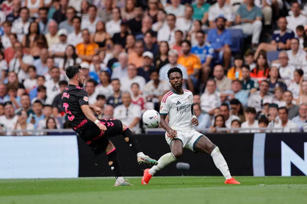 Vinicius Jr. of Real Madrid CF and Carlos Puga of Málaga CF battle for the ball during the LaLiga EA Sports match between Real Madrid CF and Málaga CF at Estadio Santiago Bernabéu on August 30, 2026, in Madrid, Spain. Photo by Manu Reino, DeFodi Images