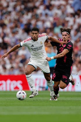 Jude Bellingham of Real Madrid CF and Angel Recio of Málaga CF battle for the ball during the LaLiga EA Sports match between Real Madrid CF and Málaga CF at Estadio Santiago Bernabéu on August 30, 2026, in Madrid, Spain. Photo by Manu Reino, DeFodi Images