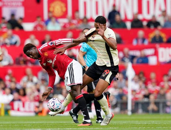 Manchester, England, 30th August 2026. Kobbie Mainoo of Manchester United, ManU challenges Emersonn of Ipswich Town during the Manchester United vs Ipswich Town Premier League match at Old Trafford, Manchester. Picture credit should read: Andrew Yates Sportimage EDITORIAL USE ONLY. No use with unauthorised audio, video, data, fixture lists, club league logos or live services. Online in-match use limited to 120 images, no video emulation. No use in betting, games or single club league player publications. SPI_032_AY_Man_Utd_Ipswich SPI-4945-0032