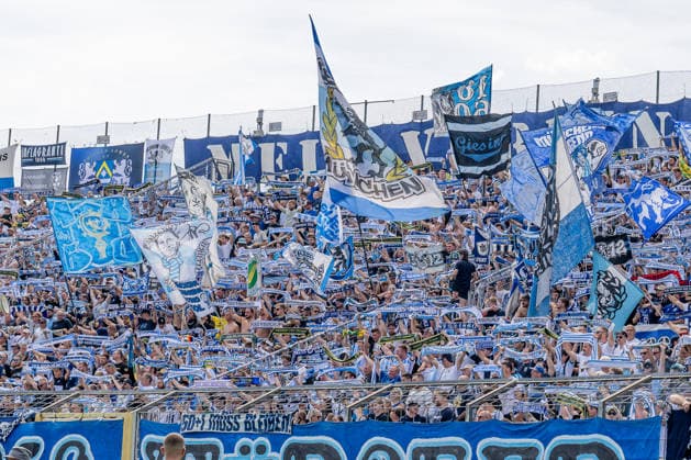 The Löwen fans in the Westkurve performing a scarf parade before kickoff: GER, TSV 1860 Munich vs. TSV Landsberg 1882, soccer, Bavarian Regional League, Matchday 6, 2026–2027 season, August 30, 2026 DFL DFB regulations prohibit any use of photographs as image sequences and or quasi-video. Photo: HMB Media, Heike Feiner Copyright: HMBxMedia HeikexFeiner