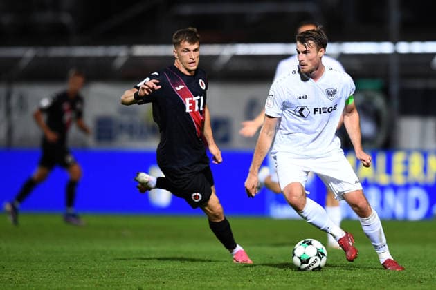 Soccer, 3rd Division, Matchday 3: FC Viktoria Köln vs. SC Preußen Münster on August 30, 2026, at Sportpark Höhenberg in Cologne. Niko Koulis (Münster) in the foreground; David Otto (Cologne) in the background. DFB regulations prohibit any use of photographs as image sequences and or quasi-video. xRx