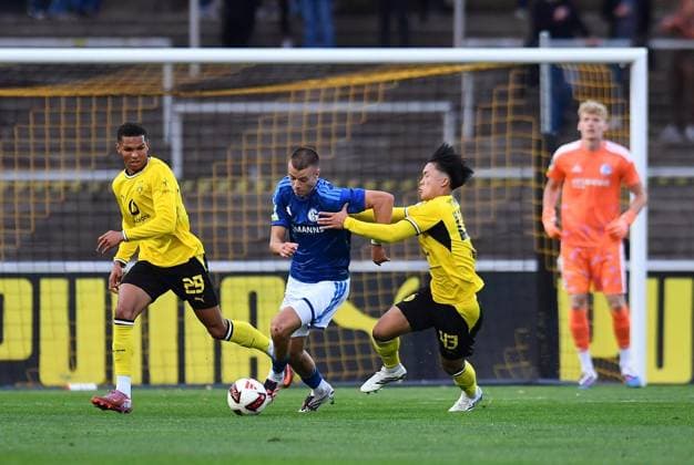 Borussia Dortmund U23 vs. Schalke 04 U23 ** FOR EDITORIAL USE ONLY ** EDITORIAL USE ONLY ** p Soccer Regionalliga West, Matchday 6: Borussia Dortmund U23 vs. Schalke 04 U23 on September 1, 2026, at Rote Erde Stadium in Dortmund. Kevin Mutove (Borussia Dortmund U23), left: Magnus Rösner (Schalke 04 U23), center: Takata Yamamoto (Borussia Dortmund U23), right: Germany, North Rhine-Westphalia, Dortmund. Copyright ThorstenxTillmann Copyright: ThorstenxTillmann doc87ezw2ds0wy15vq25vek ,EDITORIAL USE ONLY Copyright: ThorstenxTillmann