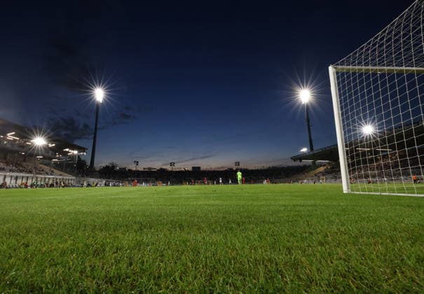 Soccer, Men s, Toto Cup, Quarterfinals, 2026–2027 Season, TSV 1860 Munich vs. TSV Buchbach, Grünwalder Stadium: Here is a view inside the Grünwalder Stadium—the municipal stadium on Grünwalder Street—showing the playing field, the main grandstand, and the west curve; the goal is on the right, along with the floodlights and the atmosphere at dusk