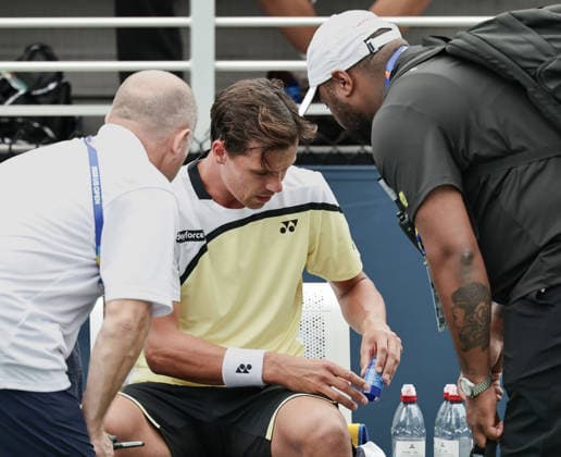 Daniel Altmaier (GER) is sitting in a chair during a break in play; a doctor and a physical therapist are giving him medication. US Open Championships, Billie Jean King National Tennis Center, Flushing Meadows, New York, USA Copyright: xJuergenxHasenkopfx