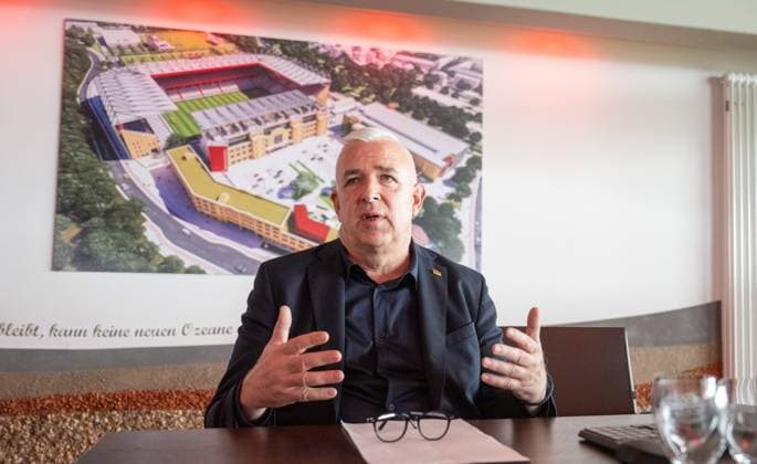 Fußball, Herren, Saison 2026 2027, 1. Bundesliga, 1. FC Union Berlin, Ordentliche Mitgliederversammlung im Stadion An der Alten Försterei, Präsident Dirk Zingler (1. FC Union) im Vorgespräch, hinten das zukünftige Stadion An der Alten Försterei, 03.09.2026, *** Soccer, Men s, 2026–2027 Season, 1. Bundesliga, 1. FC Union Berlin, Annual General Meeting at the An der Alten Försterei Stadium, President Dirk Zingler of 1. FC Union during a preliminary discussion, with the future An der Alten Försterei Stadium in the background, September 3, 2026, Copyright: xMatthiasxKochx