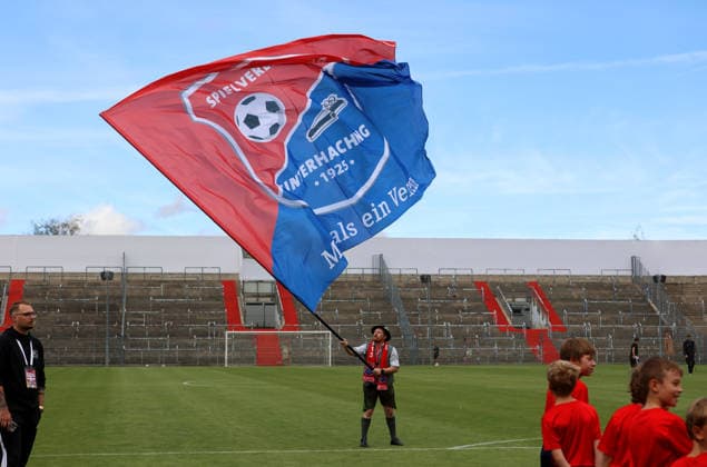 Soccer, Men s, Bavarian Regional League, 2026–2027 Season, SpVgg Unterhaching vs. FC Augsburg II, Amateur Division: A flag-waver, flag featuring the logo and coat of arms of SpVgg Unterhaching