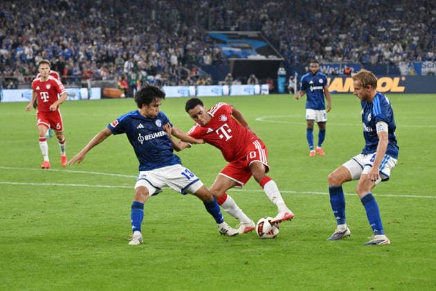 Jamal Musiala (Bayern Muenchen), mi., gegen Satoshi Tanaka (FC Schalke 04), li., rechts Timo Becker (FC Schalke 04) 05.09.2026, Fussball 1. Bundesliga, Saison 2026 2027, 2. Spieltag, FC Schalke 04 - FC Bayern München DFL regulations prohibit any use of photographs as image sequences and or quasi-video Gelsenkirchen Veltins Arena Nordrhein Westfalen Deutschland *** Jamal Musiala, Bayern Munich (center), facing Satoshi Tanaka, FC Schalke 04 (left), with Timo Becker, FC Schalke 04, on the right; May 9, 2026; Soccer, 1. Bundesliga, 2026–2027 season; Matchday 2, FC Schalke 04 vs. FC Bayern Munich. DFL regulations prohibit any use of photographs as image sequences and or quasi-video. Gelsenkirchen, Veltins Arena, North Rhine-Westphalia, Germany Team2