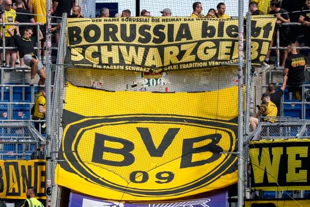 Die Fans von Borussia Dortmund (BVB 09) zeigen in der Fankurve ein Banner, Spruchband mit der Aufschrift: Borussia bleibt Schwarzgelb, darunter das Vereinslogo, Logo vom Verein, Fans, Ultras Publikum, Zuschauer, Stimmung, Atmosphäre, Stadion, 05.09.2026, Sinsheim (Deutschland), Fussball, Bundesliga, TSG 1899 Hoffenheim - Borussia Dortmund, DFB DFL REGULATIONS PROHIBIT ANY USE OF PHOTOGRAPHS AS IMAGE SEQUENCES AND OR QUASI-VIDEO. *** Borussia Dortmund BVB 09 fans display a banner in the fan section with the slogan Borussia Stays Black and Yellow, featuring the club logo below it; fans, ultras, crowd, spectators, atmosphere, stadium, September 5, 2026, Sinsheim, Germany, soccer, Bundesliga, TSG 1899 Hoffenheim vs. Borussia Dortmund; DFB and DFL regulations prohibit any use of photographs as image sequences and or quasi-video xozx