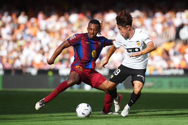 Jules Koundé of FC Barcelona and Ryunosuke Sato of Valencia CF during the LaLiga EA Sports match between Valencia CF and FC Barcelona at Mestalla on September 6, 2026, in Valencia, Spain
