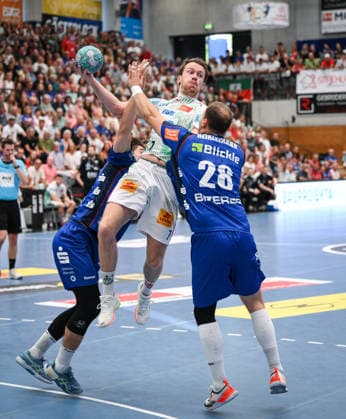 Handball 1 Bundesliga 2025–2026, June 9, 2026: HBW Balingen Weilstetten vs. SC Magdeburg; Magnus Saugstrup (center), SC Magdeburg, against Mex Raguse (left), HBW Balingen Weilstetten, and Tobias Heinzelmann (right), HBW Balingen Weilstetten
