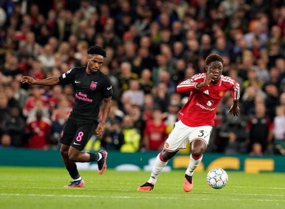 Manchester, England, 10th September 2026. Kobbie Mainoo of Manchester United, ManU glides past Christian Nwachukwu of Sabah FC during the Manchester United vs Sabah UEFA Champions League match at Old Trafford, Manchester. Picture credit should read: Andrew Yates Sportimage EDITORIAL USE ONLY. No use with unauthorised audio, video, data, fixture lists, club league logos or live services. Online in-match use limited to 120 images, no video emulation. No use in betting, games or single club league player publications. SPI_029_AY_Man_Utd_Sabah SPI-4989-0029
