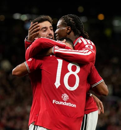 Manchester, England, 10th September 2026. Second goal scorer Bruno Fernandes of Manchester United, ManU (l) celebrates with Youri Tielemans and Patrick Dorgu of Manchester United during the Manchester United vs Sabah UEFA Champions League match at Old Trafford, Manchester. Picture credit should read: Andrew Yates Sportimage EDITORIAL USE ONLY. No use with unauthorised audio, video, data, fixture lists, club league logos or live services. Online in-match use limited to 120 images, no video emulation. No use in betting, games or single club league player publications. SPI_037_AY_Man_Utd_Sabah SPI-4989-0037
