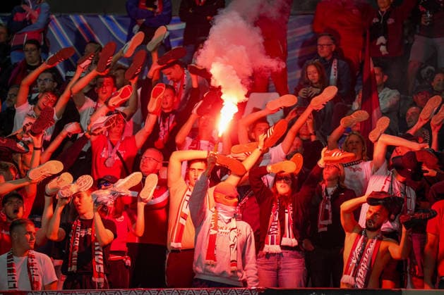 Italy Soccer UEFA Champions League 2026–2027, Matchday 1: Como 1907 vs. RB Leipzig at Giuseppe Sinigaglia Stadium. Como: RB Leipzig fans in the visitors’ section hold their shoes aloft during a choreographed display, while a fan lights a Bengalo pyrotechnic. Soccer, Champions League, RB Leipzig, away fans, spectators, fans, ultras, fan culture, fan choreography, choreography, pyrotechnics, Bengalo, smoke, visitors’ section, fan block, atmosphere, emotions Copyright: xJOERANxSTEINSIEKx