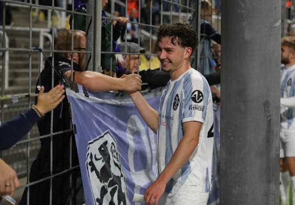 Soccer, Men s, Bavarian Regional League, 2026–2027 Season, TSV 1860 Munich vs. Schwaben Augsburg, Grünwalder Stadium: Lance Fiedler of TSV 1860 Munich celebrating and high-fiving fans in the West Stand after the game