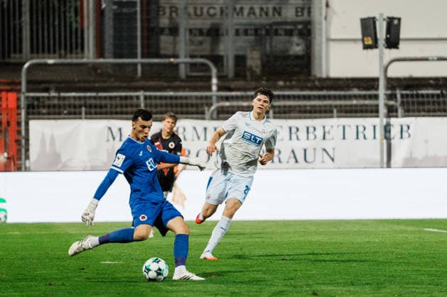 Germany, Soccer, Men s 3rd Division 2026–2027, Matchday 5: FC Viktoria Köln vs. FC Hansa Rostock, Cologne—Arne Schulz of FC Viktoria Köln takes the first kick, clears the ball, and faces pressure from Peter Kiedl of Hansa Rostock, 29 Copyright: xThiemoxRudolphx