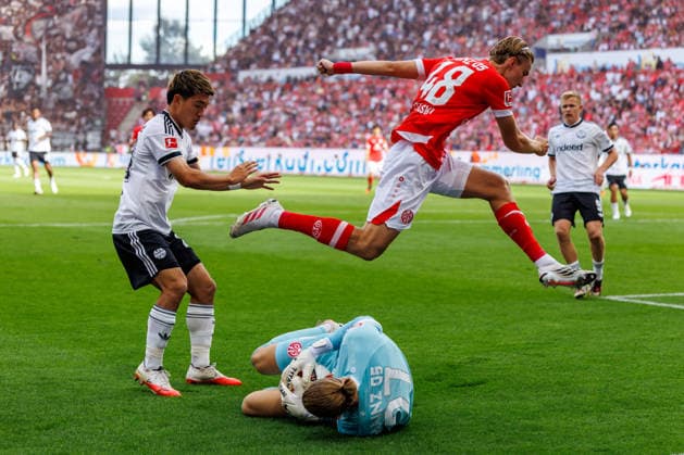MAINZ, GERMANY - SEPTEMBER 12: Robin Zentner (1. FSV Mainz 05, 27) catches a ball against Ritsu Doan (Eintracht Frankfurt, 20) and Kacper Potulski (1. FSV Mainz 05, 48) jumps over his keeper during the Bundesliga match between 1. FSV Mainz 05 vs. Eintracht Frankfurt at MEWA Arena on matchday 3 of the 1. Bundesliga on September 12, 2026 in Mainz, Germany. DFL REGULATIONS PROHIBIT ANY USE OF PHOTOGRAPHS AS IMAGE SEQUENCES AND OR QUASI-VIDEO. Rhineland-Palatinate Germany Copyright: xStephanxHahnex