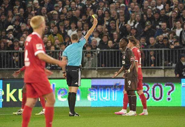 Foto : gelbe Karte von Schiedsrichter Sören Storks gegen Abdoulie CEESAY (Pauli) Fussball 2. Bundesliga , 5. Spieltag am Sa. 12.09.2026 FC St. Pauli - VfL Wolfsburg *** Photo: Referee Sören Storks shows a yellow card to Abdoulie CEESAY, St. Pauli, 2. Bundesliga, Matchday 5 on Sat, Sept. 12, 2026: FC St. Pauli vs. VfL Wolfsburg