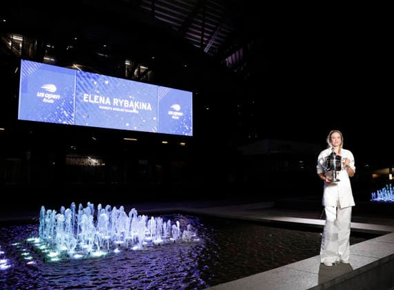 Elena Rybakina of Kazakhstan holds the championship trophy at the fountains in front of Arthur Ashe Stadium after defeating Aryna Sabalenka of Belarus in the Women s Finals match at the 2026 US Open Tennis Championship at the USTA Billie Jean King National Tennis Center in New York City on Saturday, September 12, 2026. Rybakina won with a score of 6-4, 5-7, 6-2.  NYP20260913010 JOHNxANGELILLO
