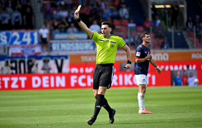 Referee Justin Hasmann shows Jonas Therkelsen (Holstein Kiel 10, not shown in the frame) a yellow card for a foul on Michael Heule (1 FC Heidenheim 1846 FCH 27, not shown in the frame) during the match between 1 FC Heidenheim 1846 FCH and Holstein Kiel KSV September 13, 2026 DFL regulations prohibit any use of photographs as image sequences and or quasi-video. 1 FC Heidenheim 1846 FCH vs. Holstein Kiel KSV