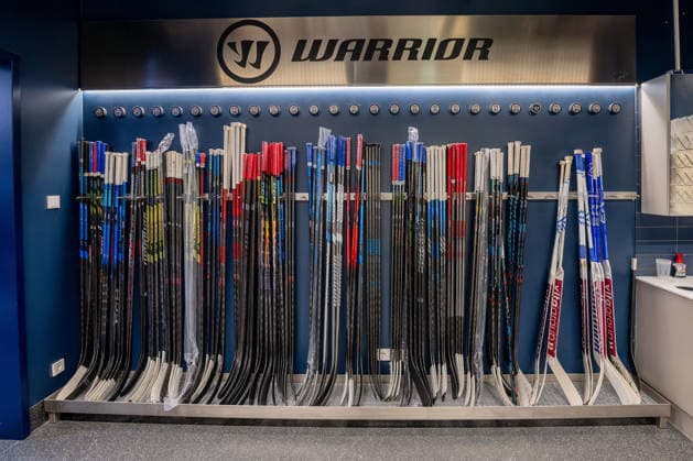Racks holding all the players hockey sticks, with pucks bearing each player s number above them: GER, EHC Red Bull Munich, ice hockey, DEL, Open Locker Room, September 14, 2026. Photo by HMB Media, Heike Feiner Copyright: HMBxMedia HeikexFeiner