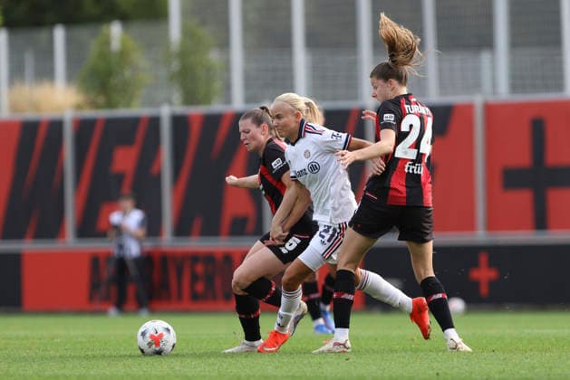 Claudia Wenger of Bayer 04 Leverkusen, Pernille Harder of FC Bayern Munich, and Lilla Turanyi of Bayer 04 Leverkusen in a one-on-one battle during the Women s Bundesliga match between Bayer 04 Leverkusen and FC Bayern Munich, Ulrich Haberland Stadium on September 14, 2026, in Leverkusen, Germany. Photo by Oliver Kaelke, DeFodi Images. Claudia Wenger of Bayer 04 Leverkusen, Pernille Harder of FC Bayern Munich and Lilla Turanyi of Bayer 04 Leverkusen battle for the ball during the Bundesliga match between Bayer 04 Leverkusen and FC Bayern Munich at Ulrich Haberland Stadium on September 14, 2026 in Leverkusen, Germany. Photo by Oliver Kaelke, DeFodi Images. DFB and DFL regulations prohibit any use of photographs as image sequences and or quasi-video. Photo by Oliver Kaelke, DeFodi Images.