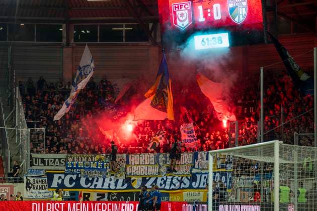 Regionalliga Northeast Season 26-27 Hallescher FC vs. FC Carl Zeiss Jena Halle, Germany September 15, 2026 Pictured: Jena fan section; fire, smoke, Bengali, Bengalis, Bengali fire, lighting, setting off fireworks, smoke bomb, Halle-Saale Leuna Chemie Stadium, Saxony-Anhalt, Germany