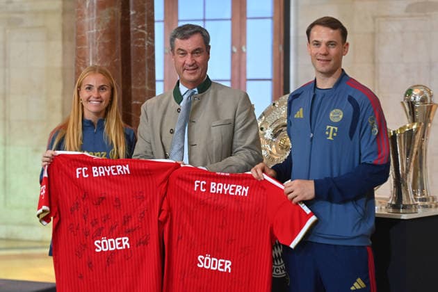 From left: Glodis Perla VIGGOSDOTTIR of FCB and Manuel NEUER, goalkeeper for Bayern Munich, present Markus SOEDER, Minister-President of Bavaria and CSU Chairman, with an autographed FC Bayern jersey each. Markus SOEDER, Minister-President of Bavaria and CSU Chairman, welcomes the championship teams of FC Bayern Munich in the Kuppelsaal at the State Chancellery in Munich on September 16, 2026