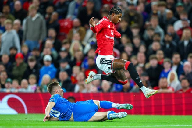 16th September 2026; Old Trafford, Manchester, England; Carabao Cup Football, Manchester United, ManU versus Brighton and Hove Albion; Marcus Rashford of Manchester United leaps over the tackle of Costinha of Brighton and Hove Albion RogerxEvans