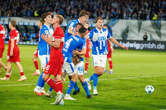 In the foreground, Alexander Groiß of VfB looks frustrated; in the background, goal celebrations—3–2. From left: Peter Kiedl (Rostock), Yannick Michaelis (Rostock), goal scorer Benno Dietze (Rostock), Kenan Fatkic (Rostock), and Florian Carstens (Rostock) GER, FC Hansa Rostock vs. VfB Stuttgart II, soccer, men’s, 3rd Division, Matchday 6, 2026–2027 season, September 16, 2026, Rostock Ostseestadion, Mecklenburg-Western Pomerania, Germany